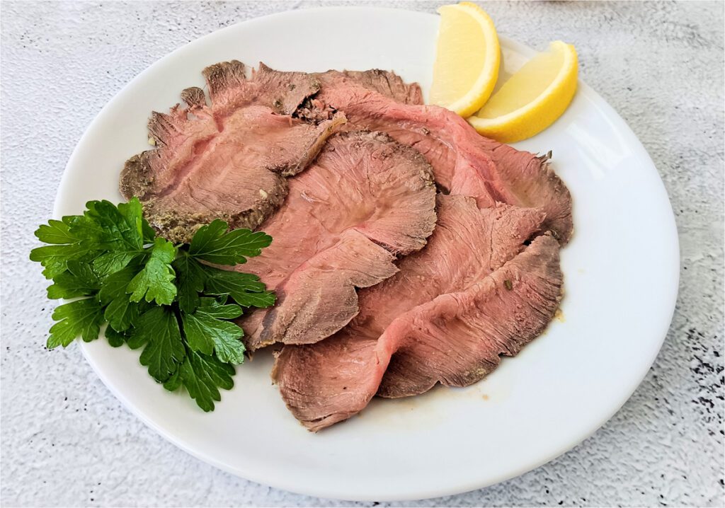 Roast beef al forno con sughetto tagliato a fette in un piatto