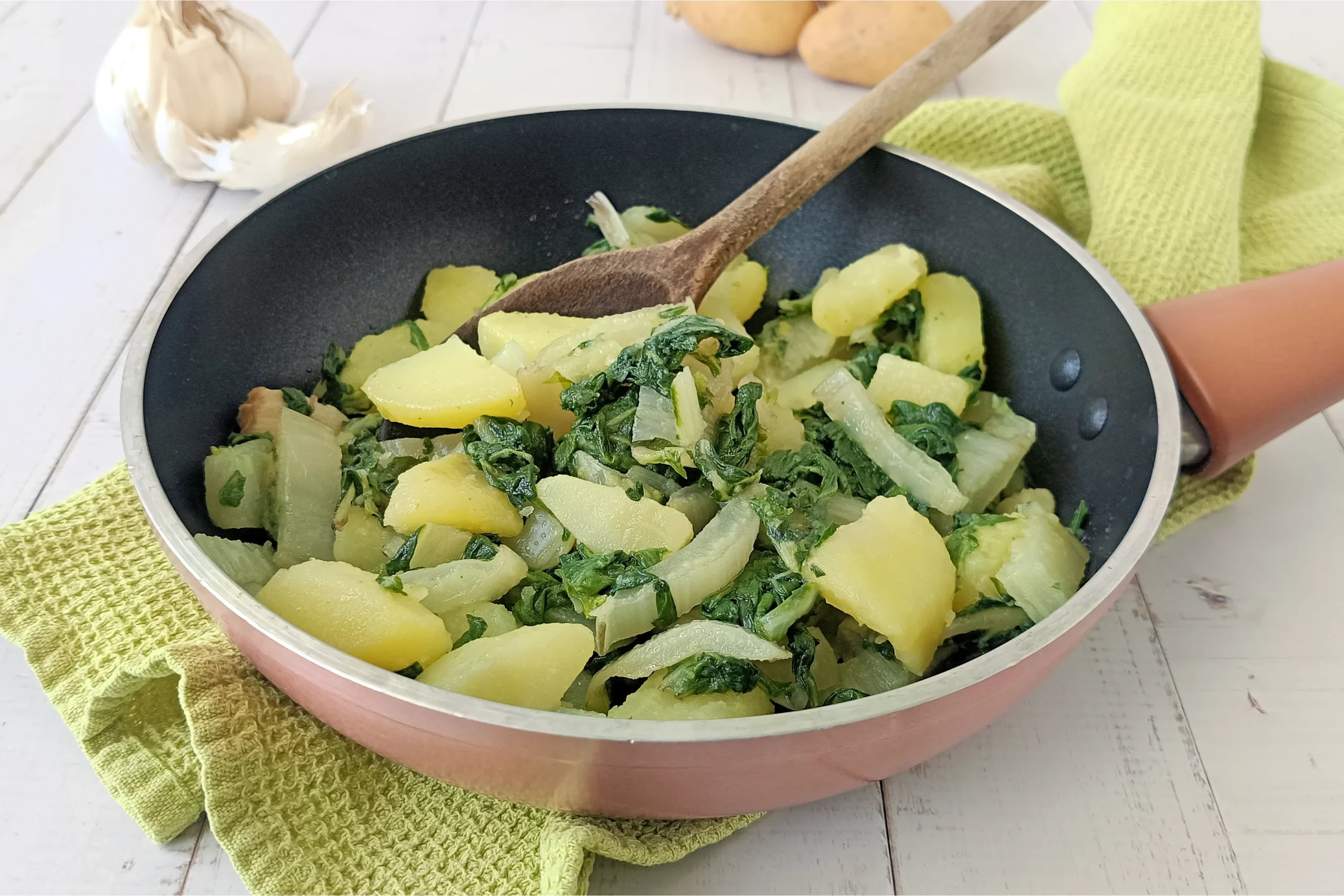 ricetta bietole e patate in padella. padella di bietole e patate appoggiata su di un tavolo